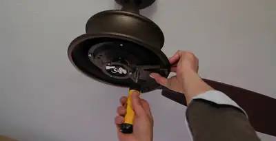 Electrician installing ceiling fan mounting bracket and fixture in Charleston, SC