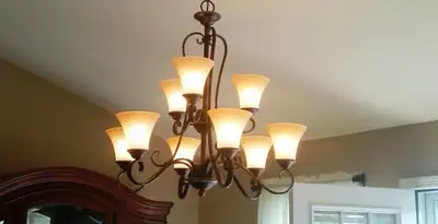 Classic ceiling chandelier installation with warm lighting in Charleston, SC