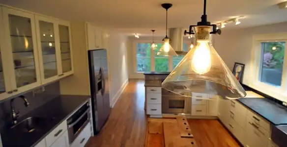 Residential electrician installing modern indoor light fixture in a home in Charleston, SC